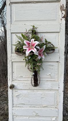 a cross made out of old doors with flowers on the front and back door handle