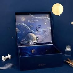 a blue box with an image of the moon and stars on it sitting next to toothbrushes