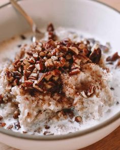 a bowl filled with oatmeal and nuts on top of a wooden table