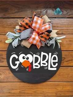 a door hanger that says gobble on it with a turkey head and leaves