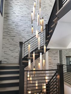 a spiral staircase with candles hanging from the handrail and stairs leading up to the second floor