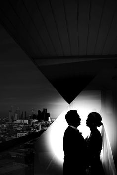 black and white photograph of bride and groom in front of the city skyline at night