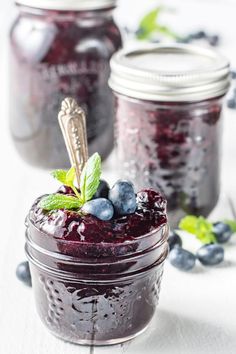 blueberry jam in a mason jar with fresh berries and mint leaves