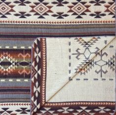 two rugs with different designs on them and one has a blanket folded over it