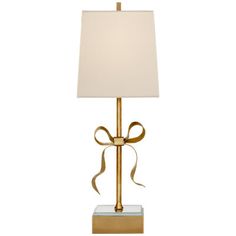 a gold lamp with a white shade on the base and a brown ribbon around it