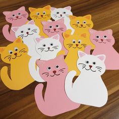 a bunch of cut out cats sitting on top of a wooden table next to each other