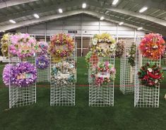 a bunch of flowers that are on some kind of metal stand in the middle of a field