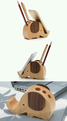 an elephant shaped wooden pen holder with two pens in it