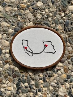 a small embroidered piece on the ground with rocks around it