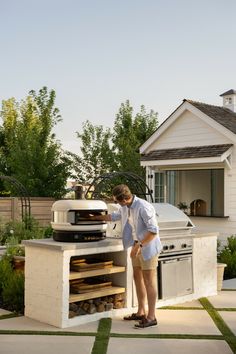 a woman standing in front of an outdoor oven