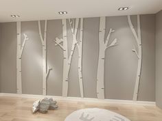 an empty room with white birch trees painted on the wall and light wood flooring