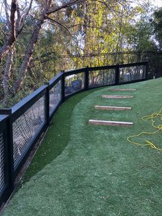 a fenced in area with grass and wooden steps