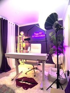 a room with purple lighting and a white desk in the middle, surrounded by chairs