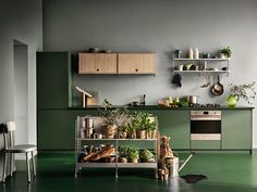 a kitchen filled with lots of green and white furniture