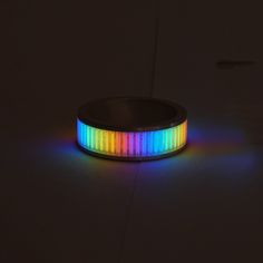 a multicolored light up bracelet sitting on top of a table