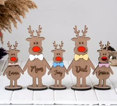 a group of wooden reindeer standing next to each other on top of a white table