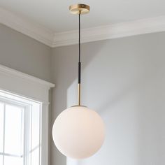 a light fixture hanging from the ceiling in a room with gray walls and white trim