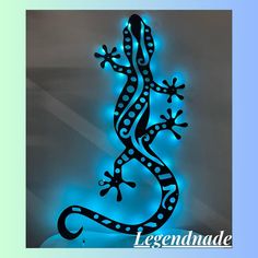 an illuminated gecko sitting on top of a white table next to a blue wall