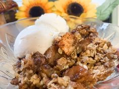 a close up of a plate of food with ice cream and sunflowers in the background