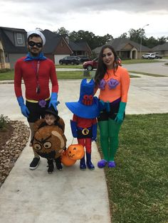 three people in costumes standing on a sidewalk