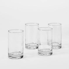 four glasses are lined up on a white surface