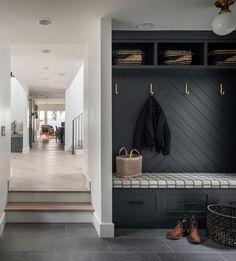 the entryway is decorated in black and white with gold handles, coat racks, and baskets