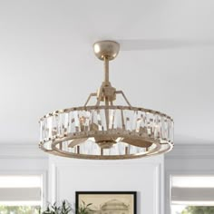 a chandelier hanging from the ceiling in a room with white walls and windows