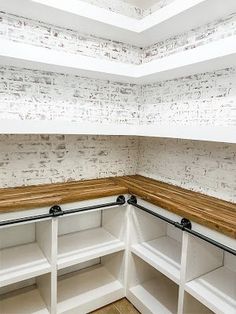 the corner of a kitchen with white cabinets and wood counter tops