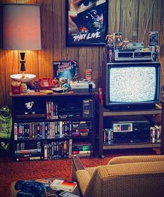 a living room filled with furniture and a tv on top of a wooden shelf next to a lamp