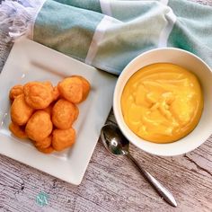 a white plate topped with tater tots next to a bowl of dip and spoon