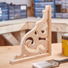 a knife and paint brush sitting on a table next to a wooden block with the shape of a cat