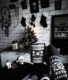 a person laying on the floor with their feet up next to a christmas tree and skull decorations