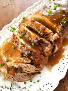 a white plate topped with meat covered in gravy