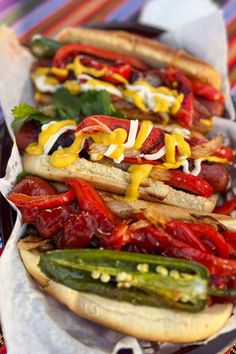 three hot dogs with toppings on them are lined up