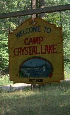 the welcome sign to camp crystal lake is posted in front of some trees and grass