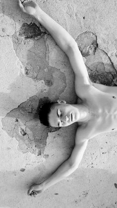 a naked man laying on top of a sandy beach