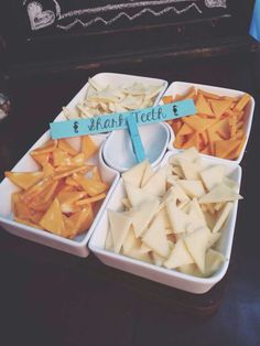 there are many different types of cheeses in trays on the table with signs that say happy teeth