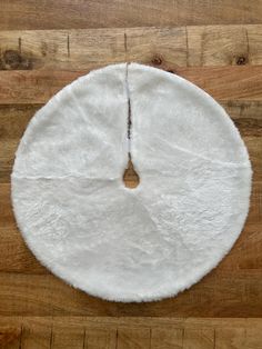 a white round rug on top of a wooden floor next to a piece of wood