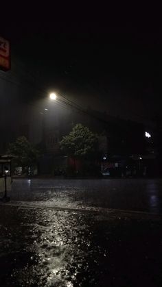 a street at night with the lights on and water puddles all over the ground