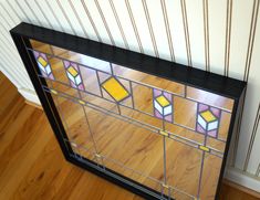 a stained glass window sitting on top of a wooden floor