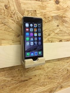 an iphone in a wooden holder on a wall