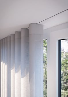 a room with white walls and curtains on the windowsill