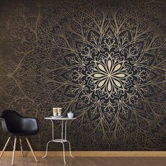 a black and gold wallpaper with an intricate design on the wall, next to a small table