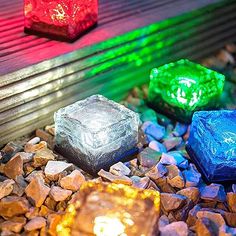 three different colored lights sitting on top of rocks