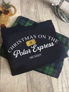 christmas on the polar express mommy t - shirt and plaid blanket next to holiday decorations