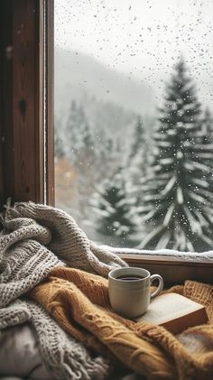 a cup of coffee sitting on top of a window sill next to a book