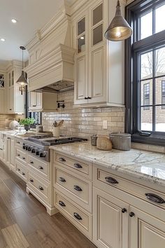 a kitchen filled with lots of white cabinets and counter top space next to a window