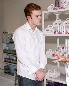 a man and woman standing in front of shelves with bottles