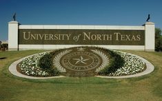 the university of north texas sign is shown in front of a grassy area with flowers