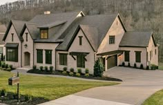 a large house with two car garages and lots of windows on top of it